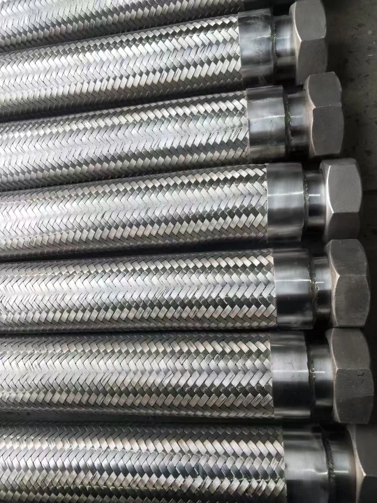 Close-up of SS304 braided flexible hoses with welded hex nut ends, lined up side by side